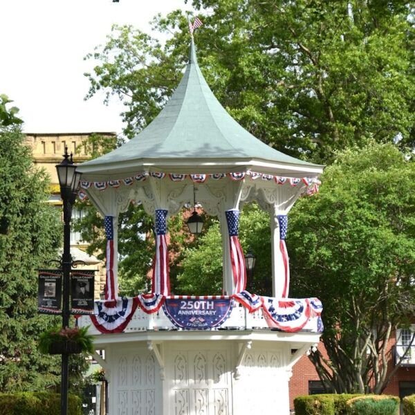 White gazebo decorated with patriotic red, white, and blue bunting.