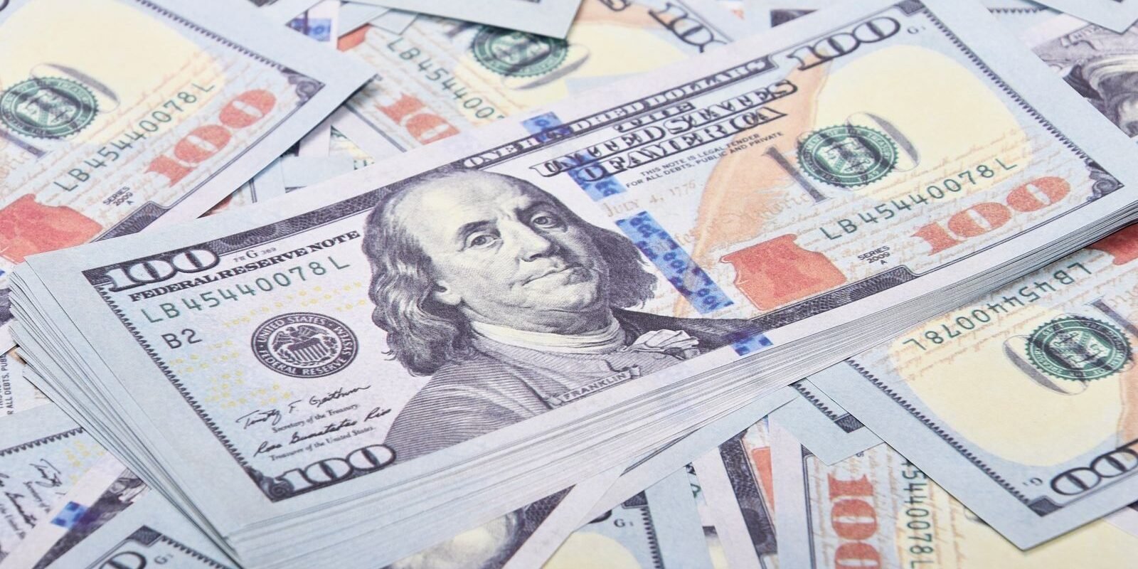 Crisp US hundred dollar bills stacked neatly in a detailed close-up image, ideal for finance themes.