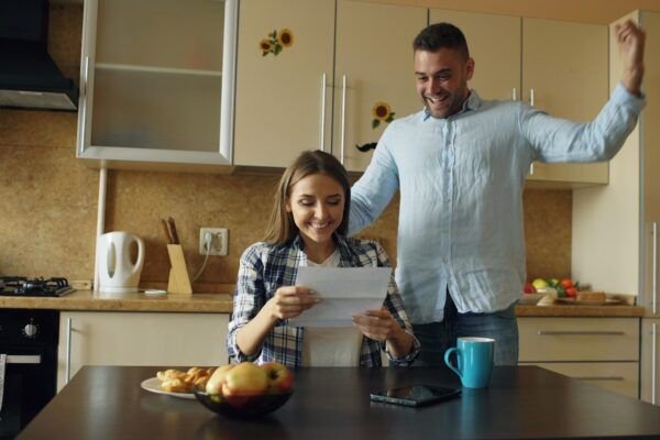 Couple celebrating good news in the kitchen